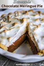 A close-up view of a homemade chocolate meringue pie with a slice missing from it.