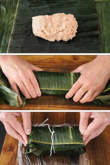 An overhead view of a mound of ground pork laying in the middle of several stacked pieces of banana leaves and then a person rolling the leaves over the pork, and then the same person folding in the ends of the leaves that have been tied with a string.