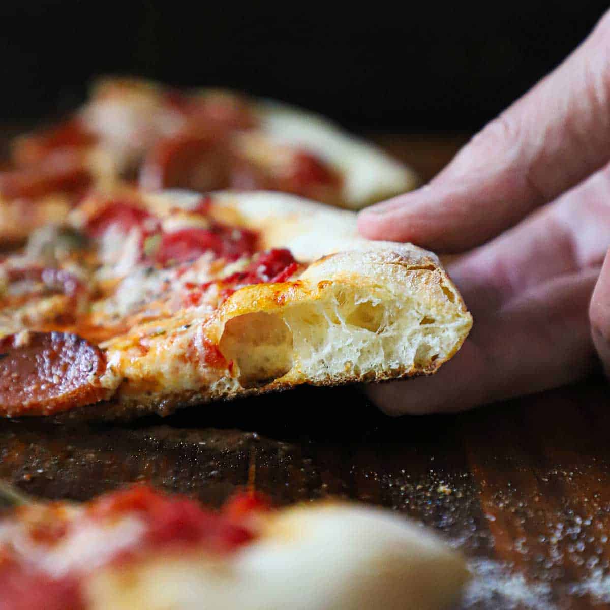 New York-style pizza showing a thin foldable crust with browned edges