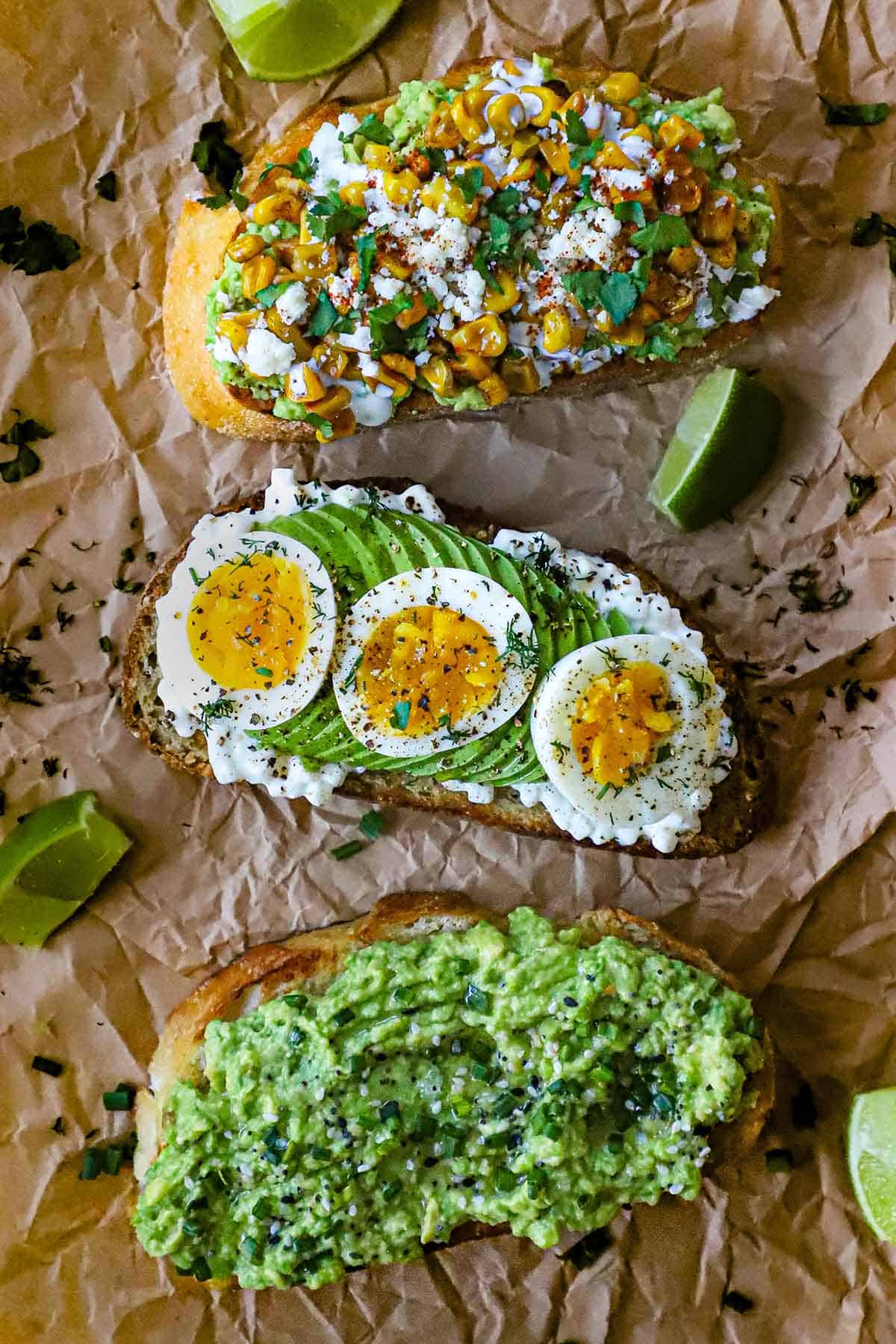 An overhead view of Avocado Toast - Ways, with the Classic version on the end, the cottage cheese and egg in the middle, and the eloté version on the other end.