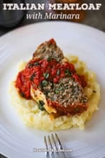 A slice of The Best Juicy Italian Meatloaf with Marinara Glaze resting on a pile of mashed potatoes on a white dinner plate.