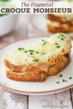 A close-up view of a freshly made Essential Croque Monsieur and is garnished with a sprinkling of snipped chives.