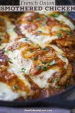 A close-up view of French onion smother chicken in a large black cast-iron skillet.