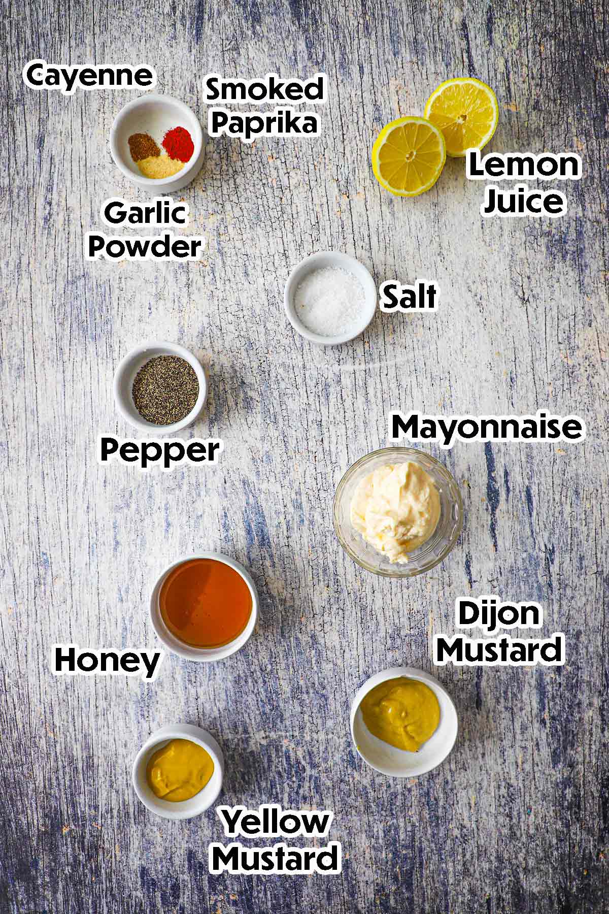 An arrangement of ingredients for Restaurant-Style Honey Mustard Dressing including mayonnaise, Dijon mustard, yellow mustard, honey, lemon juice, and seasonings.
