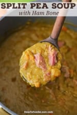 A large wooden ladle being used to lift up a serving of split pea soup with ham bone from a pot of the same.