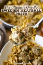 A person using a spoon to raise a serving of Swedish meatball pasta with two meatballs resting on top of the creamy pasta.