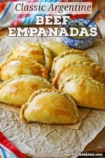 A straight-on view of two rows of Argentine Beef Empanadas on a sheet of crinkled brown paper.
