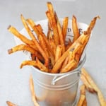 A close-up view of homemade French fries in a small metal pale.