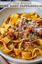 A close-up view of a pasta bowl filled with a serving of slow-braised pork ragu pappardelle.