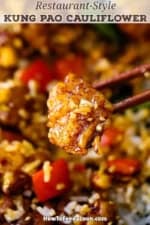 A close-up view of a pair of chop sticks holding up a piece of Kung Pao Cauliflower over a bowl of the same.