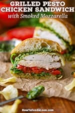 A straight-on view of a grilled pesto chicken sandwich that has been cut in half and is resting on brown sandwich paper.