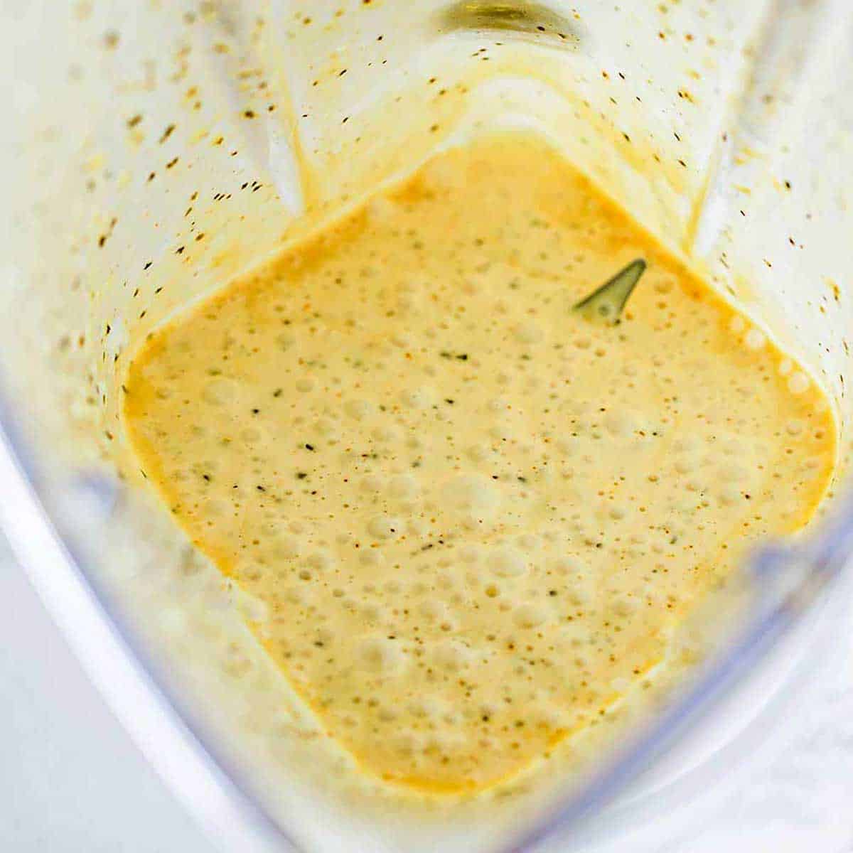 An overhead view of the inside of a blender that contains freshly prepared blender-style hollandaise sauce.