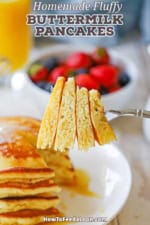 A person holding a fork that has three triangular pieces of buttermilk pancakes on it.