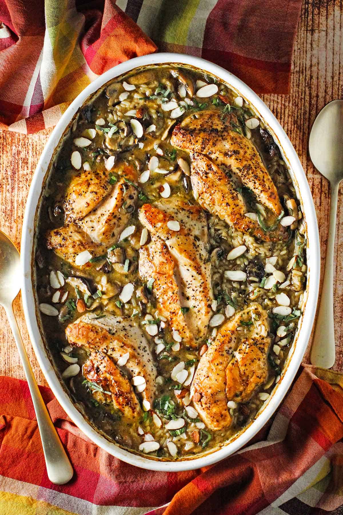 An overhead view of an oval baking dish filled with chicken and sage casserole. 