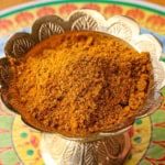 A close-up view of a golden decorative bowl filled with homemade curry powder.