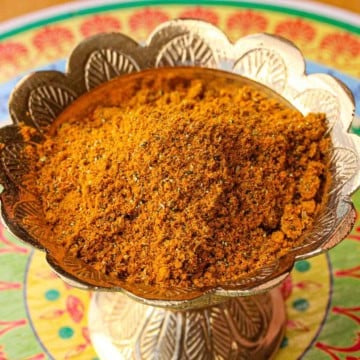 A close-up view of a golden decorative bowl filled with homemade curry powder.