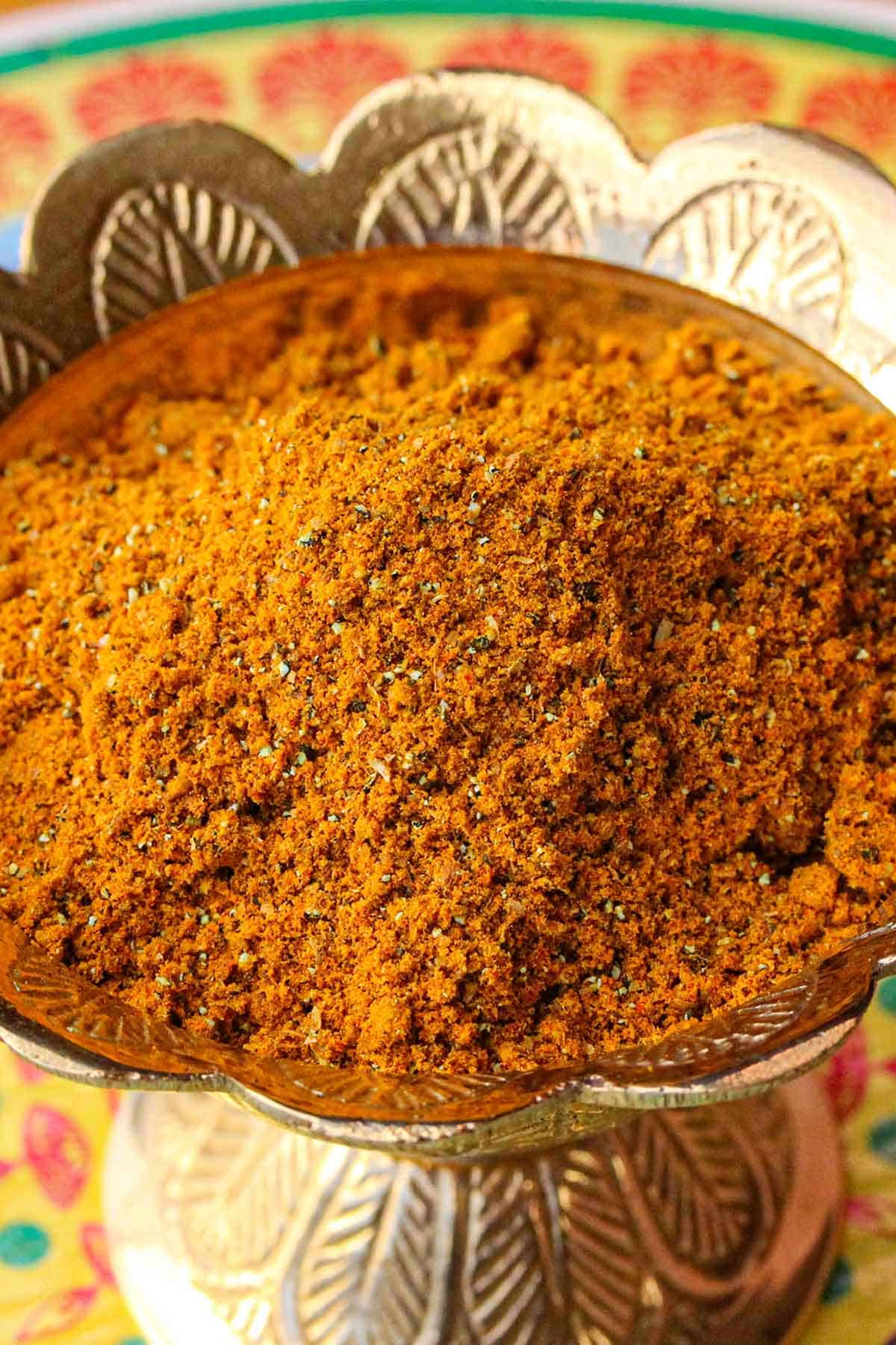 A close-up view of a golden decorative bowl filled with homemade curry powder.