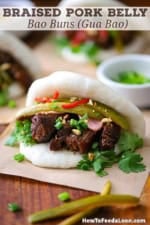 A straight-on view of a Braised Pork Belly Bao Buns each resting on a square piece of brown paper on a large wooden cutting board.